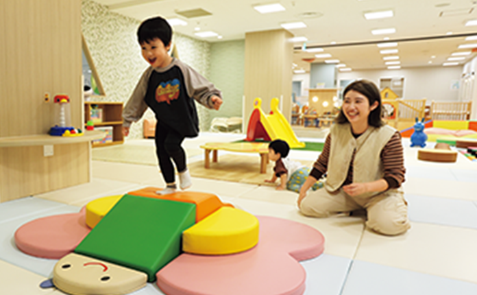 プレイルームで遊ぶ子と保護者の写真