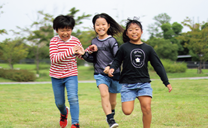 一緒に走る3人のこどもたちの写真