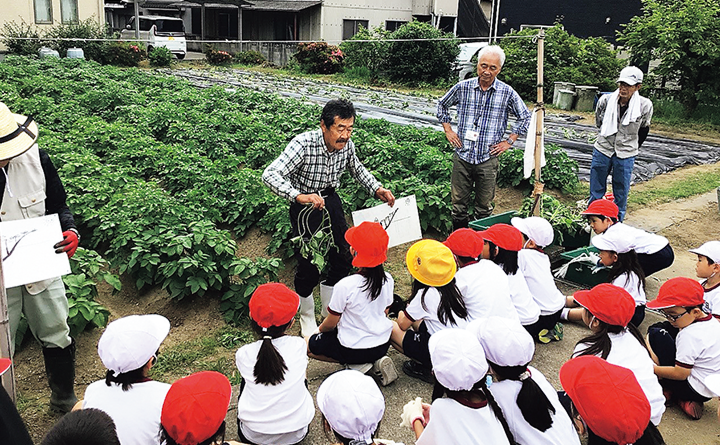 農園スタッフがこどもたちに説明する様子