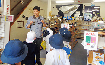 紙ヒコーキ博物館でこどもたちを案内する様子