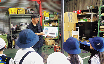 工場スタッフが児童たちに説明する様子