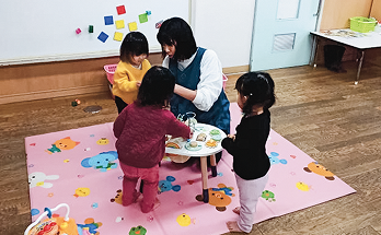 保育士とこどもたちが遊んでいる様子