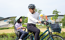 2人乗りの自転車に一緒に乗る親子