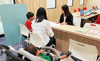 つながルームでスタッフと話す親子